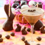 A chocolate martini served in a glass garnished with a mini chocolate bunny.