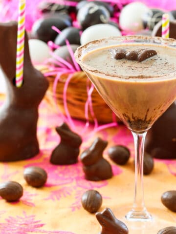 A chocolate martini served in a glass garnished with a mini chocolate bunny.