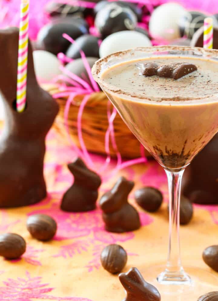 A chocolate martini served in a glass garnished with a mini chocolate bunny.