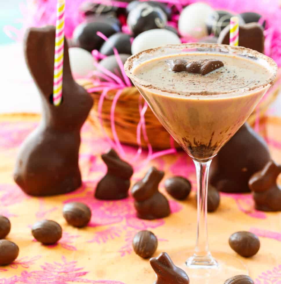 A chocolate martini served in a glass garnished with a mini chocolate bunny.