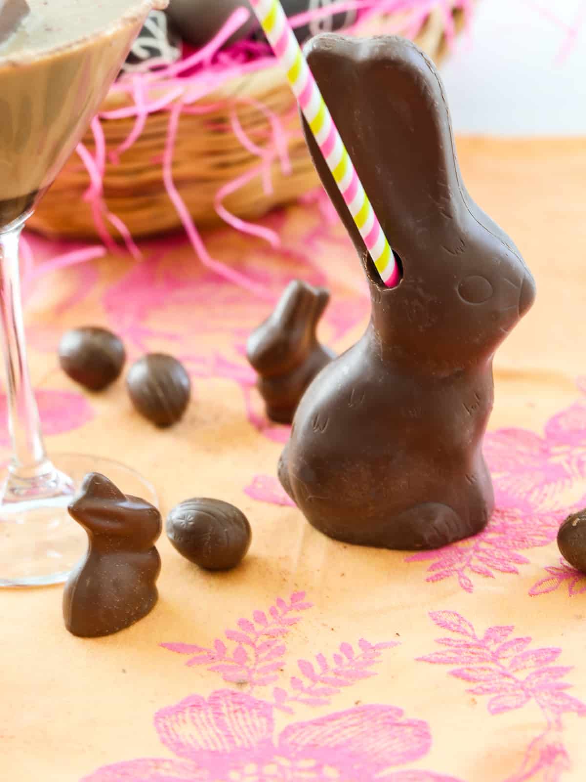 A chocolate Easter bunny filled with a chocolate martini cocktail and a colorful straw.