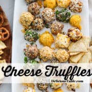 A rectangle white platter loaded with cheese truffle appetizers, little cheese balls rolled in colorful toppings and served with crackers and pretzels.