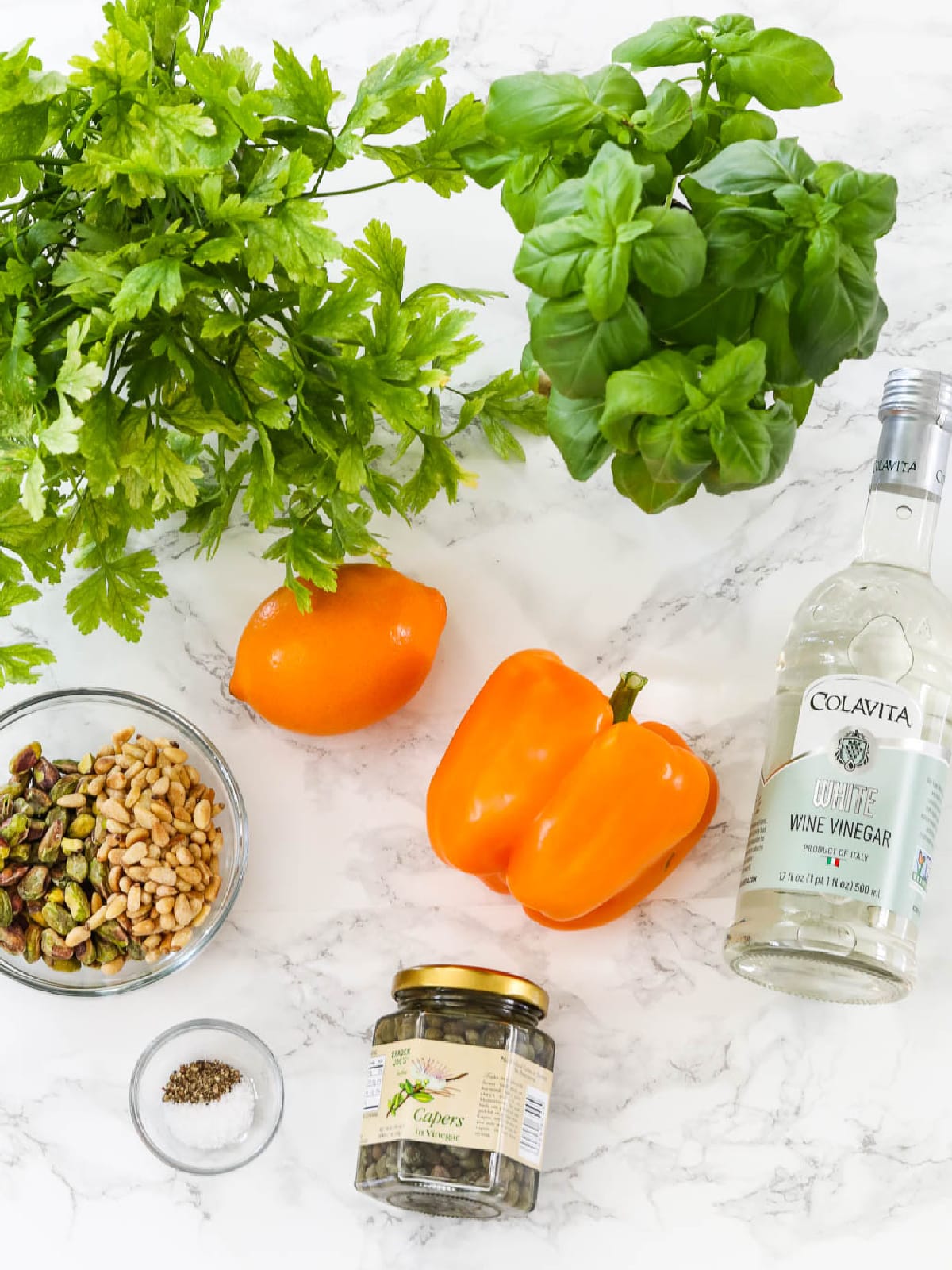 Fresh produce and ingredients on a kitchen counter to make a gremolata recipe.