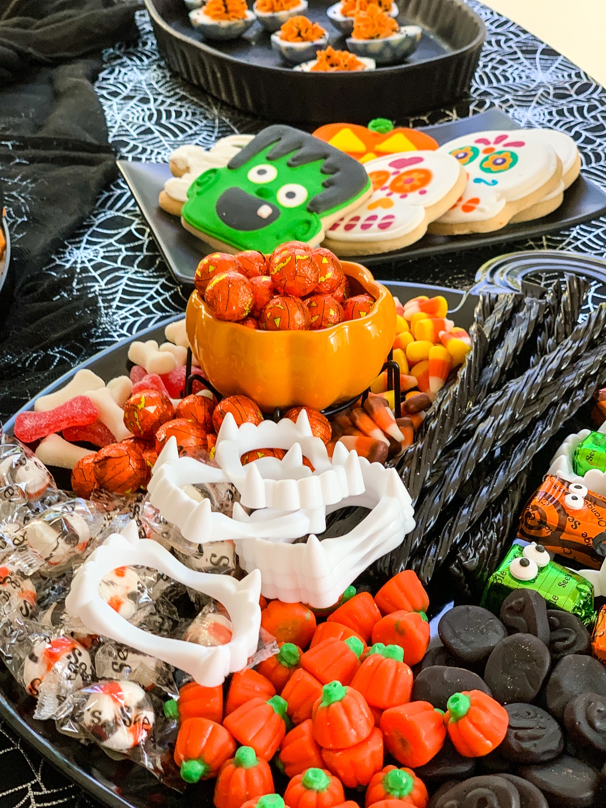 All kinds of sweets and candy on a Halloween candy board at a party. 