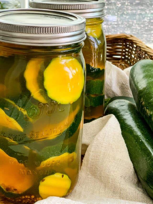 Close up of zucchini pickles in a quart glass mason jar.