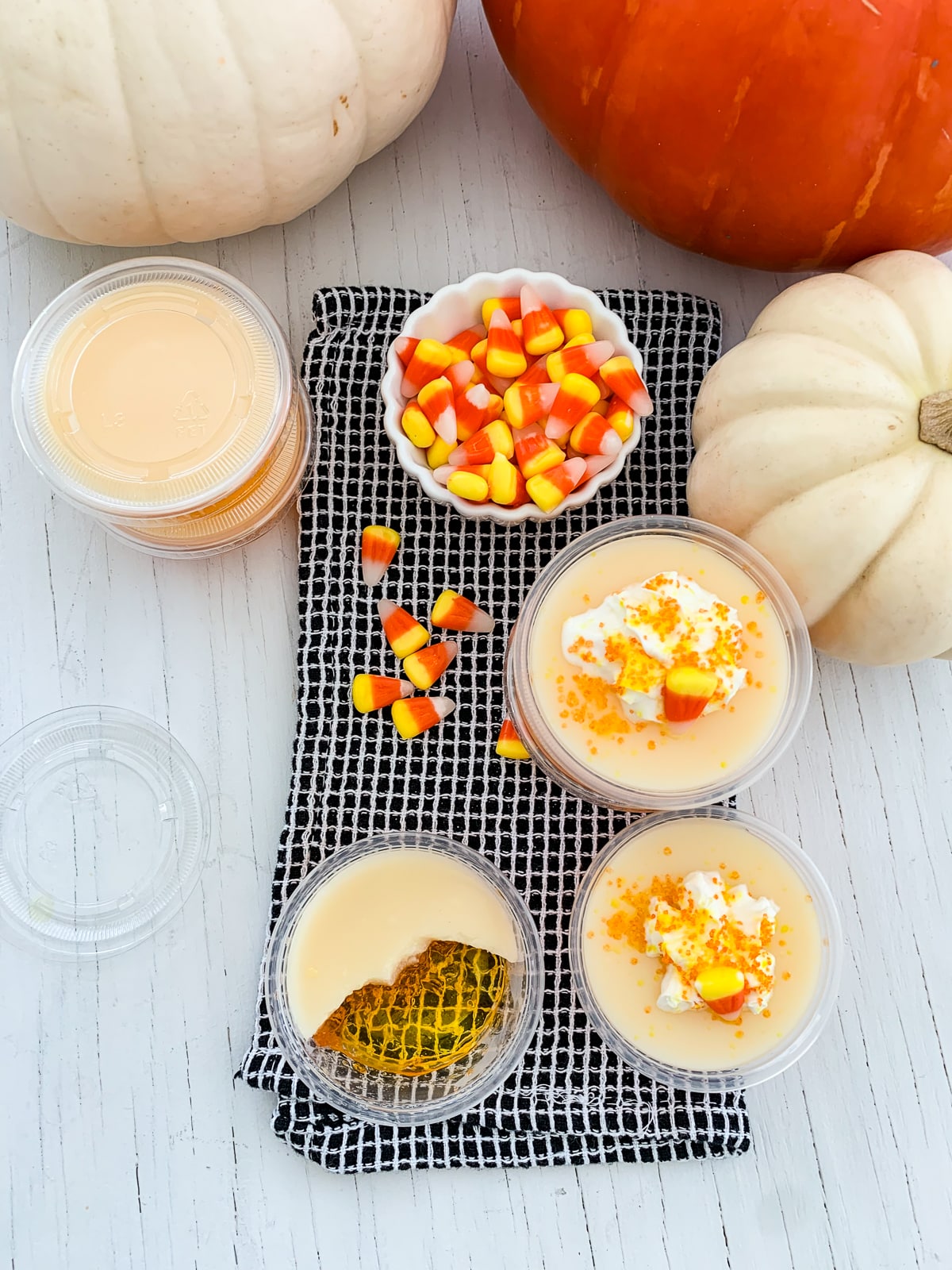 Looking down on a table with a half sipped candy corn Jello shot and others nearby at a party.