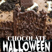 A Halloween cake with chocolate tombstones, crushed oreos for dirt, and white chocolate bones.