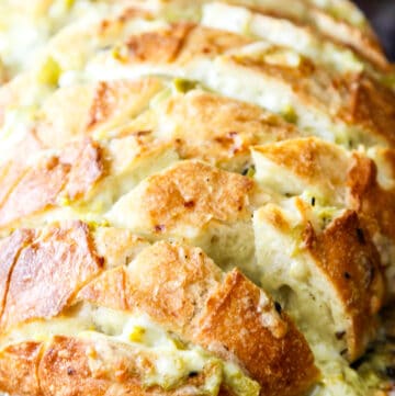 A loaf of sliced bread filled with a cheesy mixture to make a pull apart crack bread recipe.