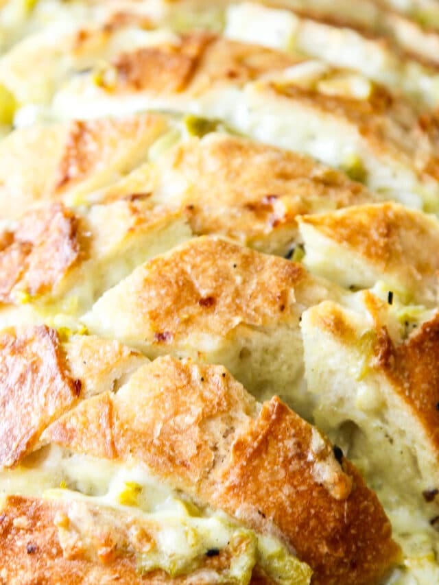 A loaf of sliced bread filled with a cheesy mixture to make a pull apart crack bread recipe.
