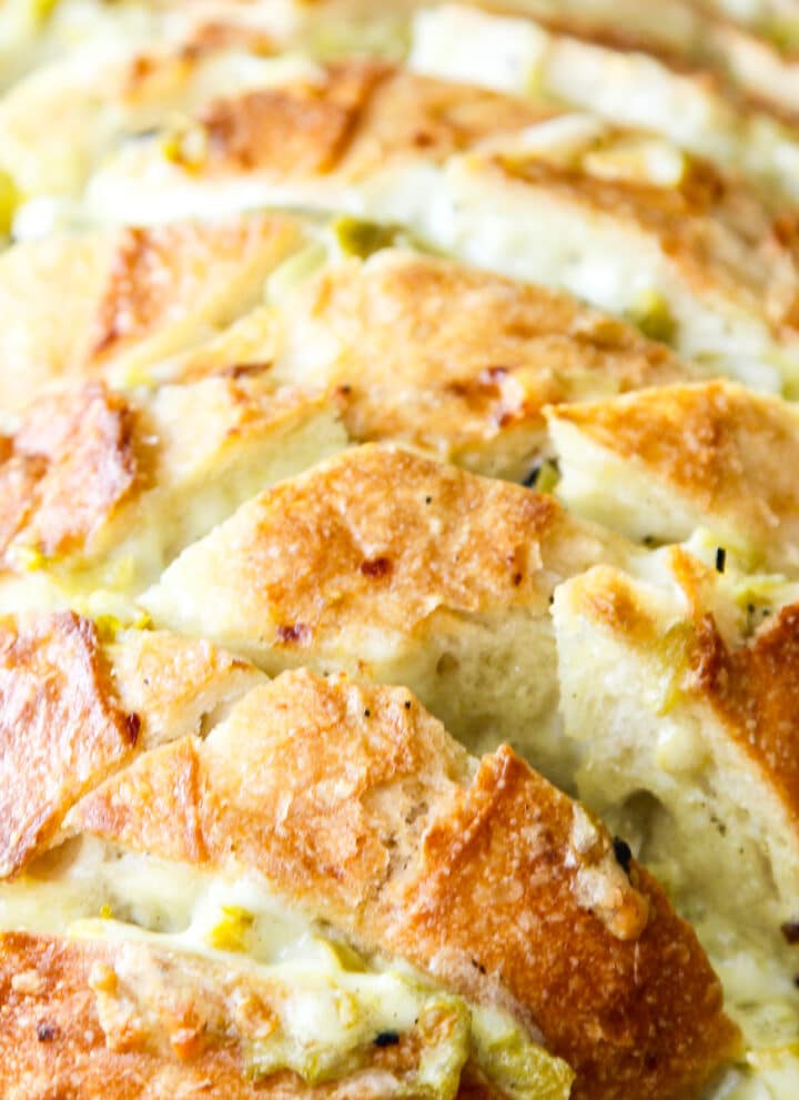 A loaf of sliced bread filled with a cheesy mixture to make a pull apart crack bread recipe.