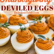 Thanksgiving deviled eggs garnished with sage and thyme on a vintage piece of wood.