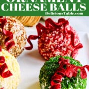 A white square platter with four colorful round cheese balls decorated like Christmas tree ornaments.
