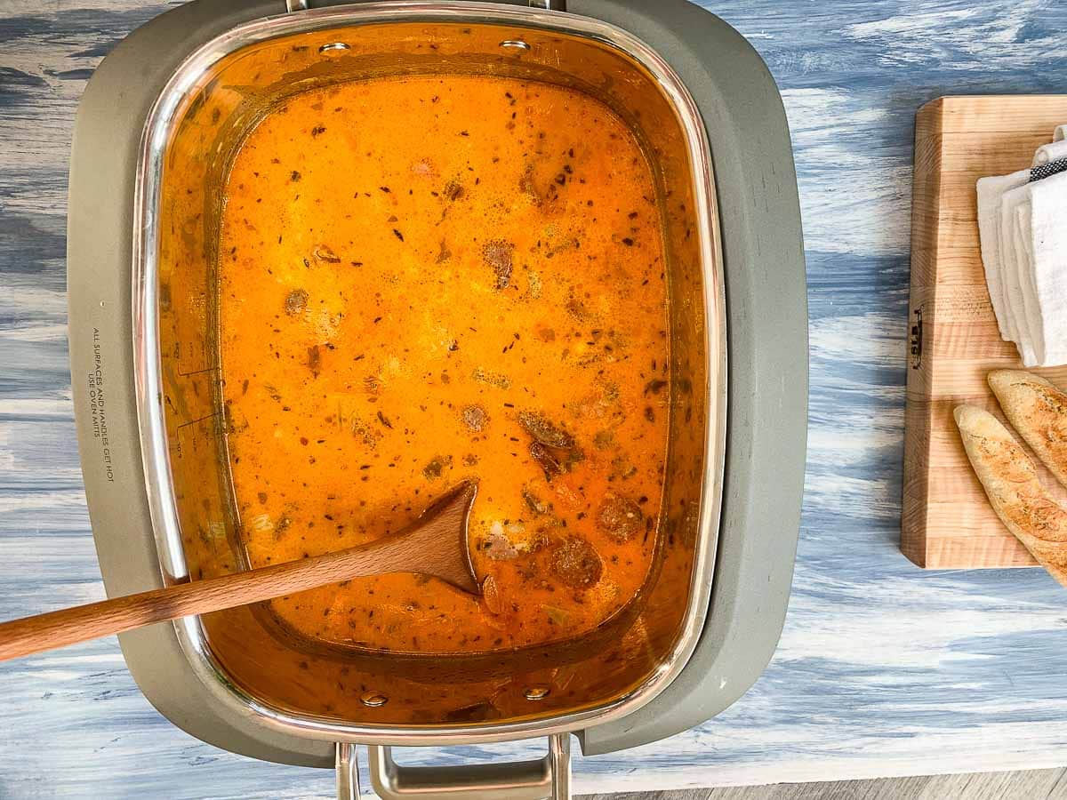 Looking down into a crock pot of creamy sausage and potato soup. 