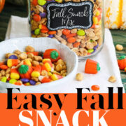 A tall clamp jar filled with a recipe for Fall Snack Mix with peanuts, candy corn and M&M candy.